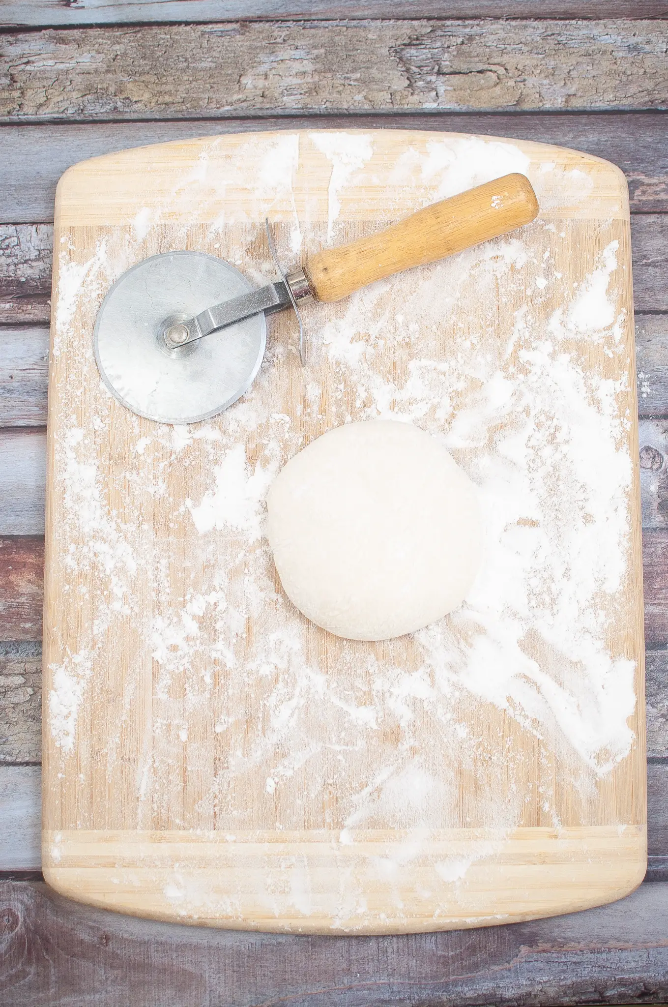 unformed pizza dough on a cutting board. 