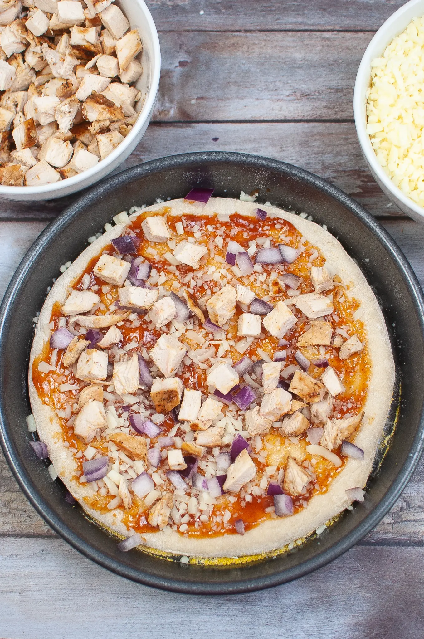 Pizza dough with bbq sauce, cheese, onion and chicken.
