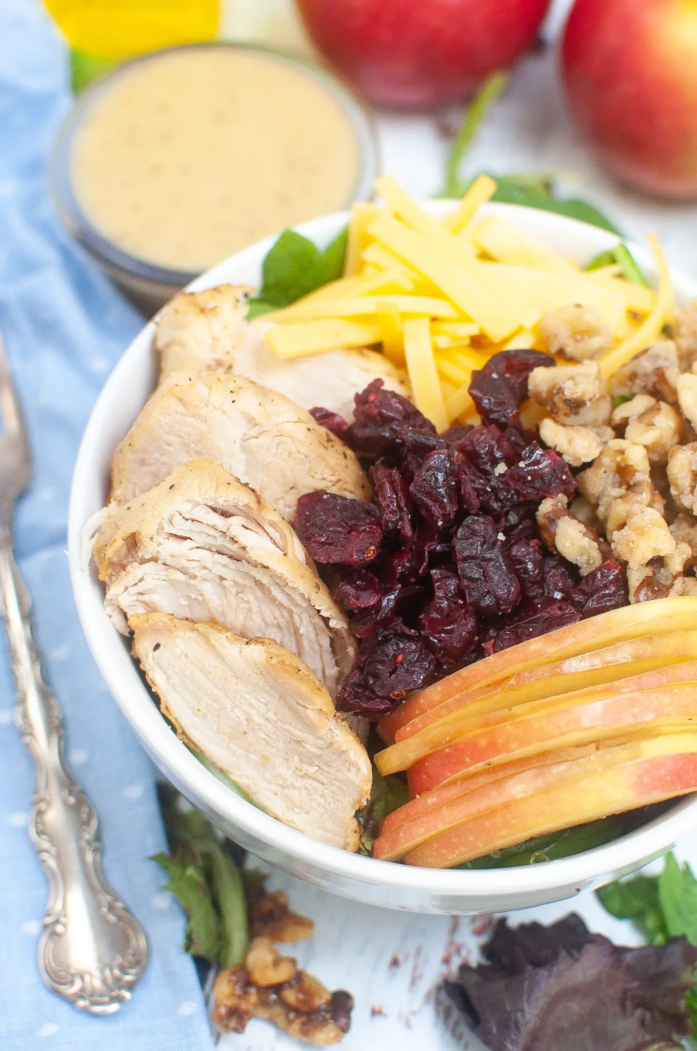 Salad topped with Chicken, cheese, walnuts, cranberries, and apples.