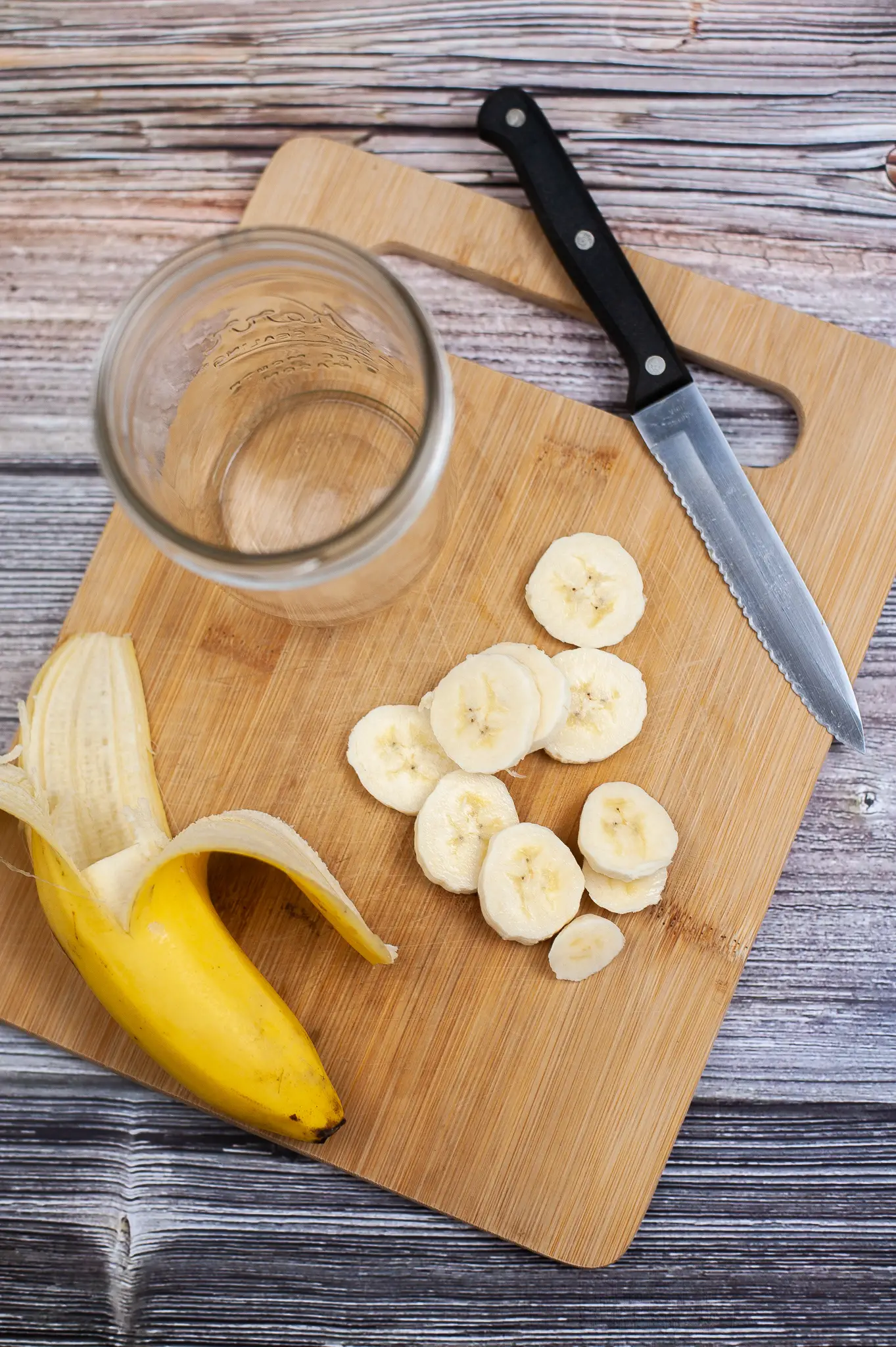 Cutting board with sliced banana.