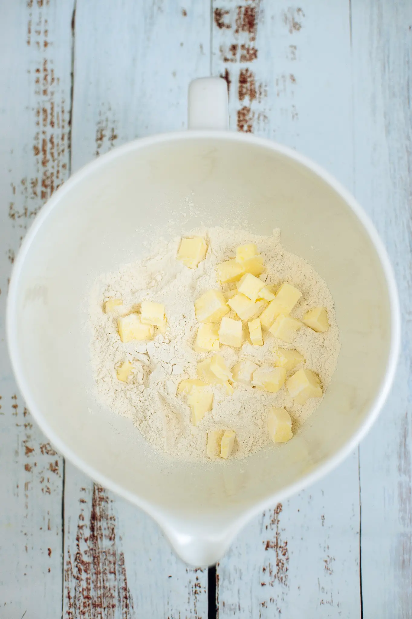 Cubed butter being added to flour mixture.