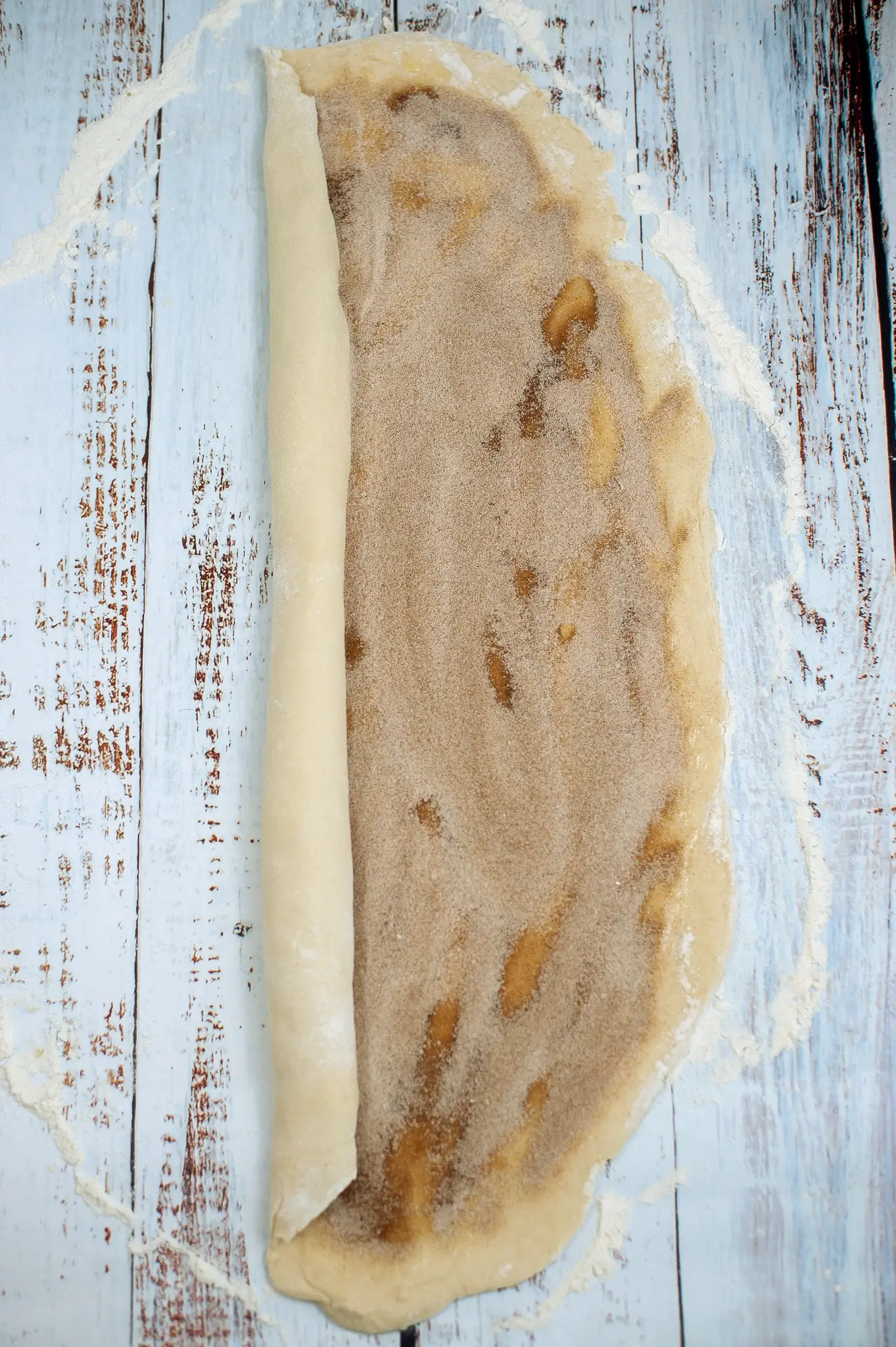 Cinnamon roll dough being rolled.