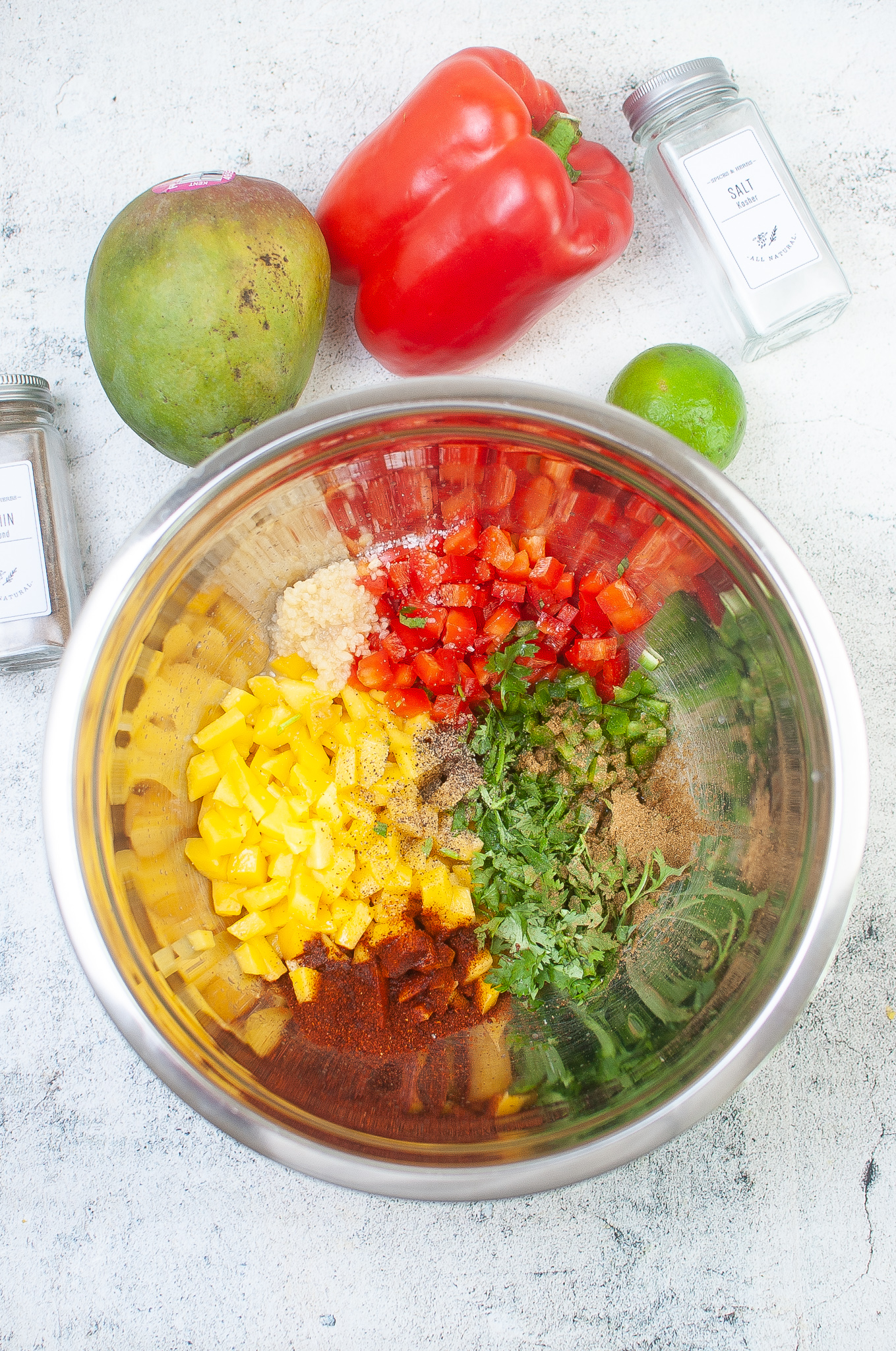 Prepared mango salsa ingredients in a bowl prior to being mixed.