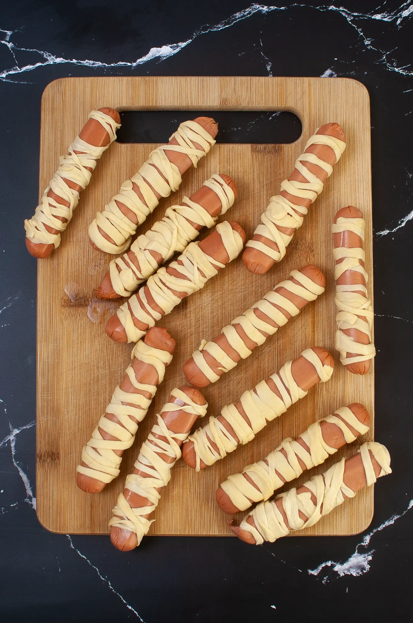 Hot dogs are wrapped in strips of crescent rolls.