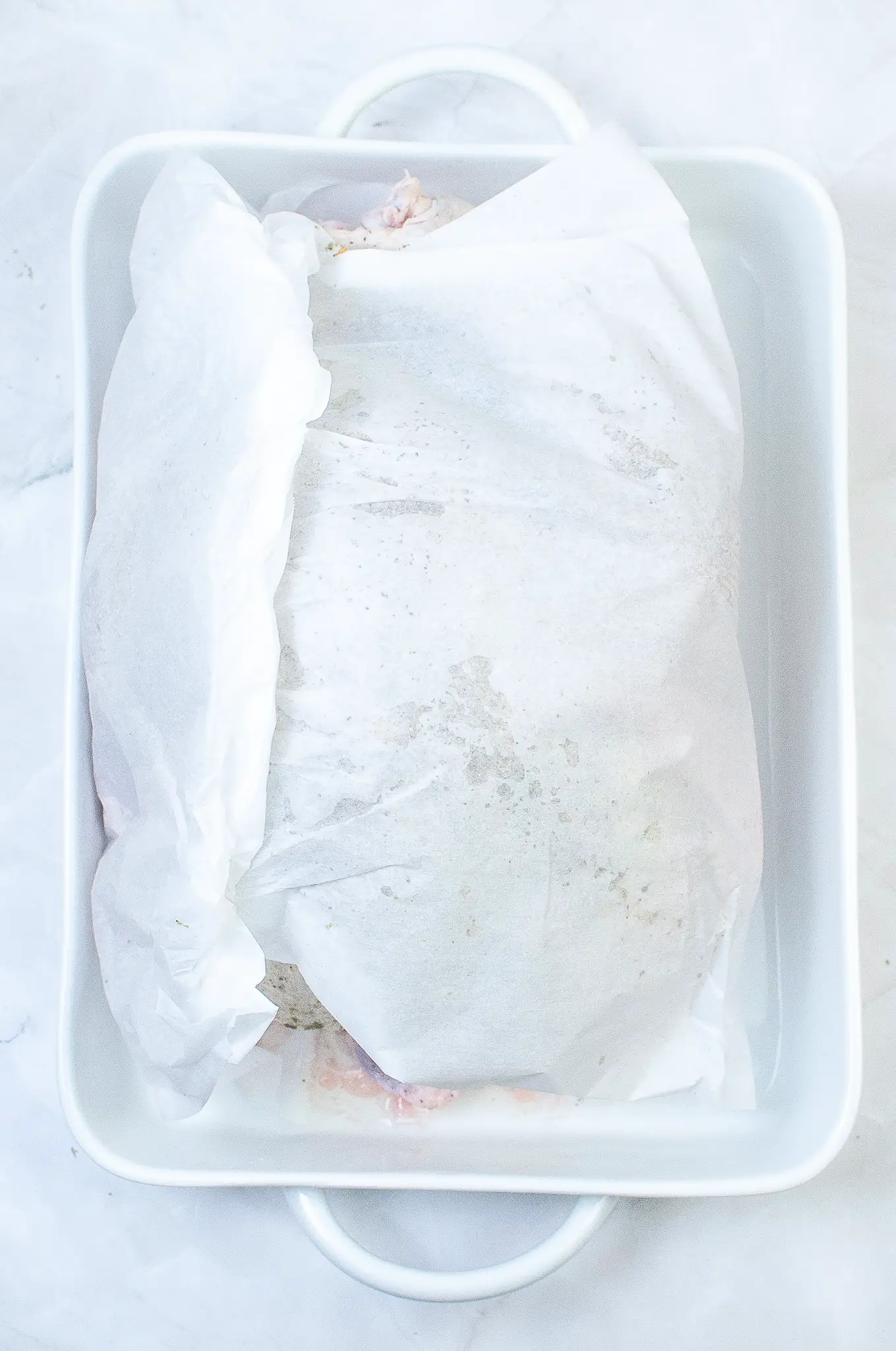 Parchment paper covering the raw turkey.