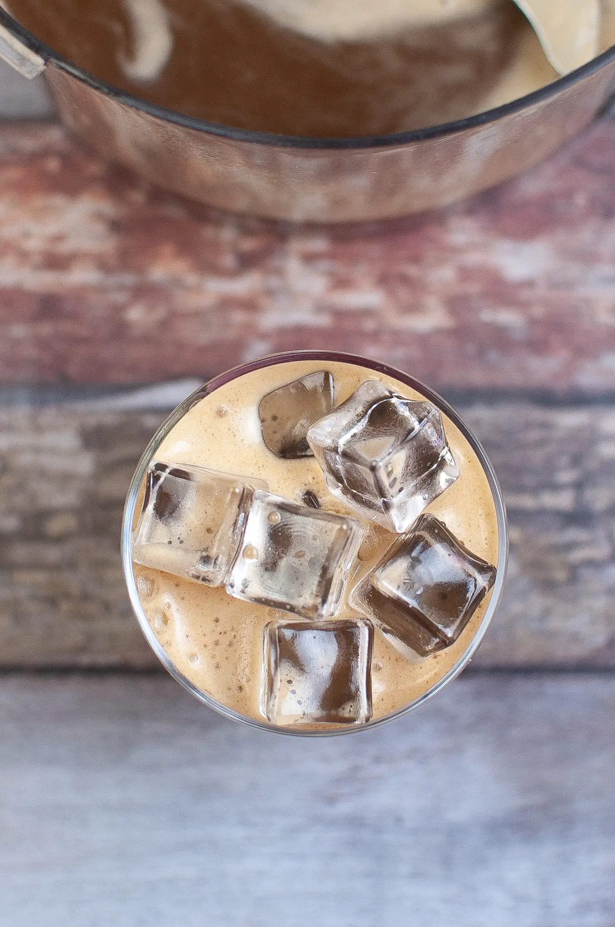 All ingredients for Iced Bulletproof coffee blended in a glass over ice.